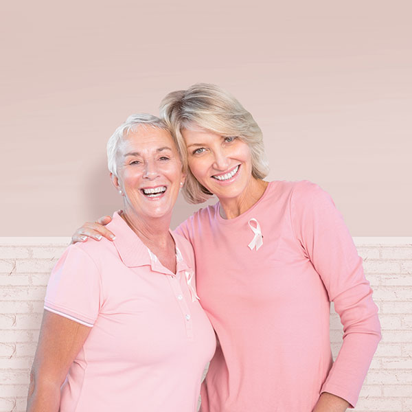 Two women hugging, supporting breast cancer awareness